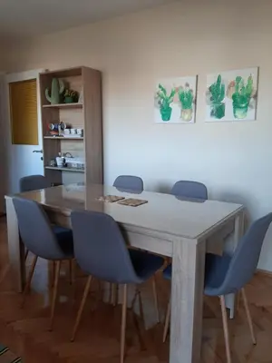 a dining room with a table and blue chairs at Magnolija in Banja Luka