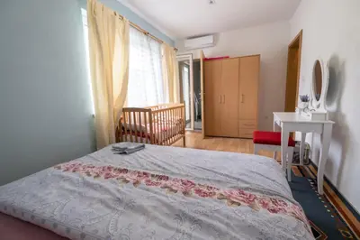 a bedroom with a bed and a table and a window at River Bank Apartments & Castle view in Bihać