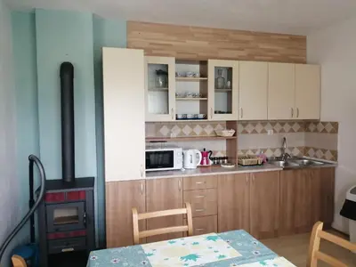 a small kitchen with a stove and a table with a table at River Bank Apartments & Castle view in Bihać