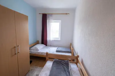 a small bedroom with a bed and a window at River Bank Apartments & Castle view in Bihać