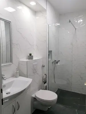 a white bathroom with a toilet and a shower at Apartman Maja in Banja Luka