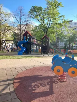 a playground with a blue toy train on the ground at Apartman Maja in Banja Luka