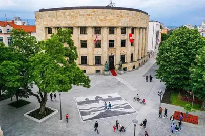 a group of people walking in front of a building at Apartman Maja in Banja Luka