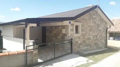 a small brick building with a gate at Weekend House Petar in Lusnić