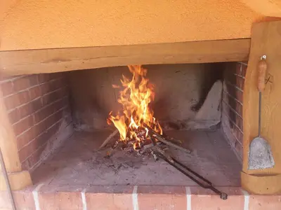 a brick oven with a fire in it at Weekend House Petar in Lusnić