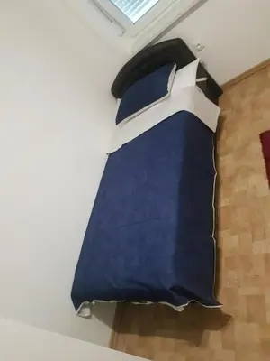 a bedroom with a blue bed with a window at Apartment Centar LUX in Banja Luka