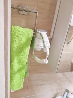 a green towel and a blow dryer in a bathroom at Apartment Centar LUX in Banja Luka