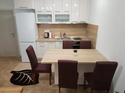 a kitchen with a wooden table and chairs at Apartment Centar LUX in Banja Luka