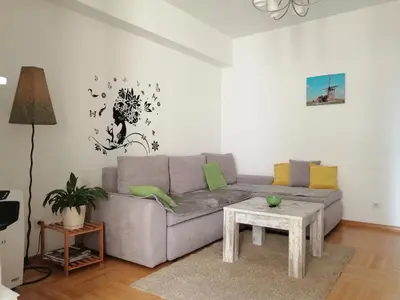 a living room with a gray couch and a table at Apt Ana in Banja Luka