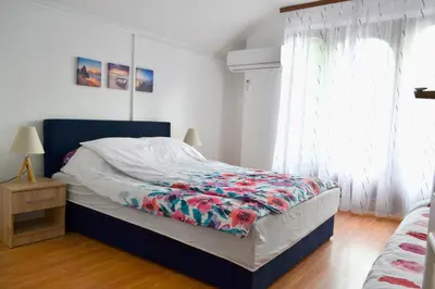 a bedroom with a bed with a floral bedspread at Riverside apartment #1. View over Fortress Kastel in Banja Luka