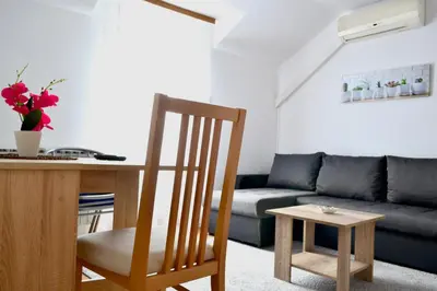 a living room with a table and a couch at Riverside apartment #1. View over Fortress Kastel in Banja Luka