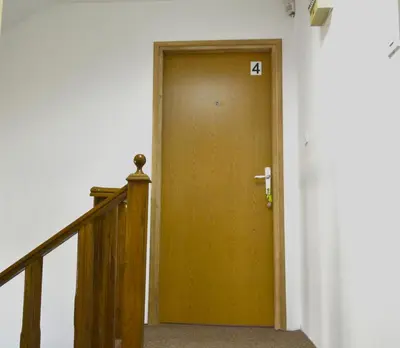 a wooden door with the number on it in a hallway at Riverside apartment #1. View over Fortress Kastel in Banja Luka