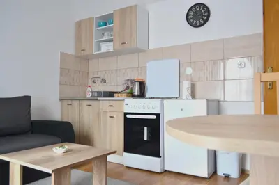 a kitchen with a white refrigerator and a table at Riverside apartment #1. View over Fortress Kastel in Banja Luka