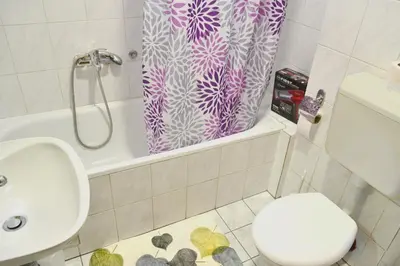 a bathroom with a toilet and a shower curtain at Riverside apartment #1. View over Fortress Kastel in Banja Luka