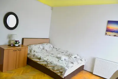 a bedroom with a bed and a dresser and a mirror at Riverside apartment #1. View over Fortress Kastel in Banja Luka