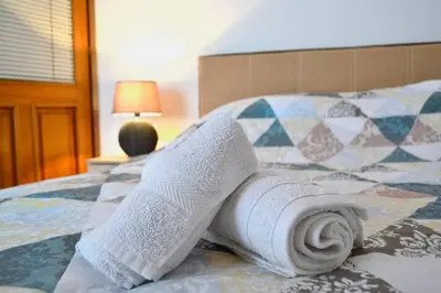 a pile of towels sitting on top of a bed at Riverside apartment #1. View over Fortress Kastel in Banja Luka