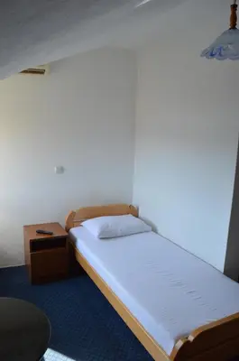 a small bedroom with a bed and a night stand at Motel Signal in Banja Luka