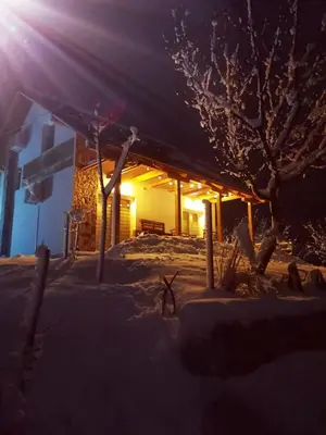 a log cabin in the snow at night at Nektar Park Villa Sara in Bihać