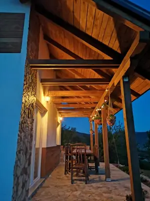 a patio with a table and chairs under a wooden pergola at Nektar Park Villa Sara in Bihać