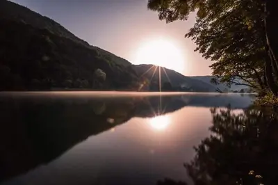 a view of a lake with the sun reflecting on the water at Nektar Park Villa Sara in Bihać