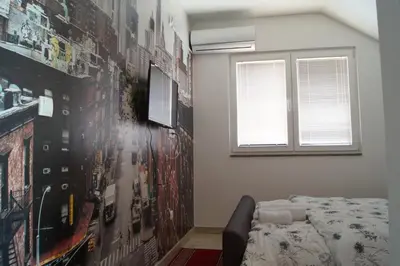 a bedroom with a bed and a wall with posters at SOBE ROOMS GAVRILO in Banja Luka