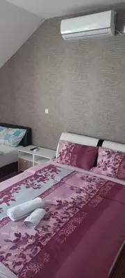 a bedroom with a bed with a purple comforter at SOBE ROOMS GAVRILO in Banja Luka