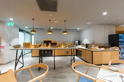 a kitchen with tables and chairs in a room at Courtyard by Marriott Banja Luka in Banja Luka