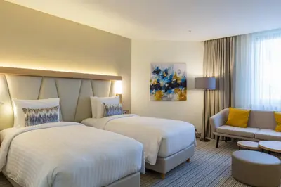 a hotel room with two beds and a couch at Courtyard by Marriott Banja Luka in Banja Luka