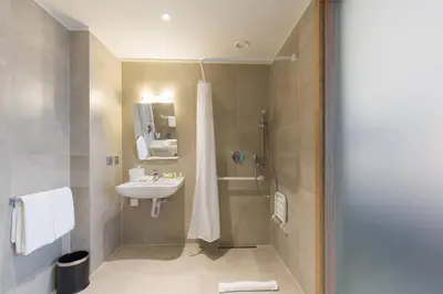 a bathroom with a shower and a sink at Courtyard by Marriott Banja Luka in Banja Luka