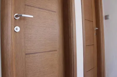 a wooden door with a metal handle on it at Apartmani Ramonda in Teslić