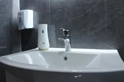 a white sink with a faucet on it in a bathroom at Apartmani Ramonda in Teslić