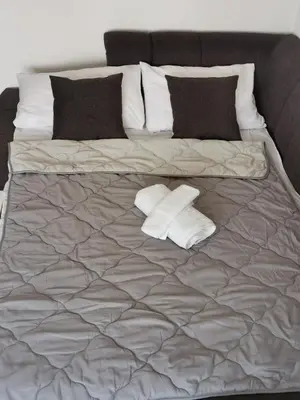 a bed with two pillows and two towels on it at Apartman MMS in Teslić