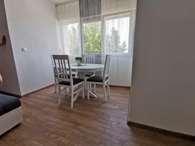 a dining room with a table and chairs and a window at Apartman MMS in Teslić