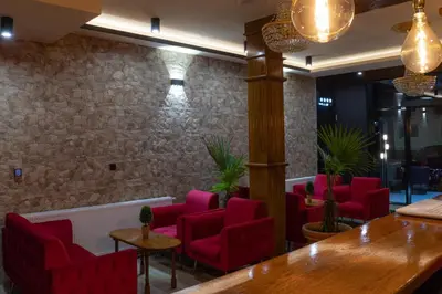 a waiting room with red chairs and a table at HOTEL Villa Grande in Bugojno