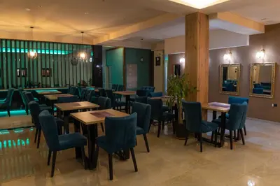 a restaurant with wooden tables and blue chairs at HOTEL Villa Grande in Bugojno