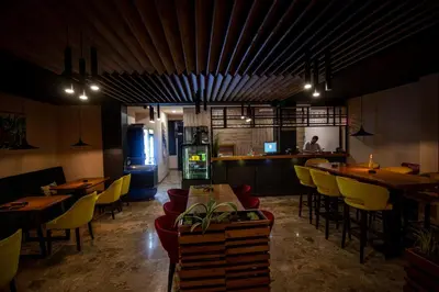 a restaurant with tables and yellow chairs and a bar at HOTEL Villa Grande in Bugojno