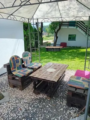 a patio with a table and two chairs and an umbrella at Ravne Apartman in Visoko