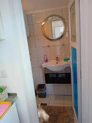 a small bathroom with a sink and a mirror at Ravne Apartman in Visoko