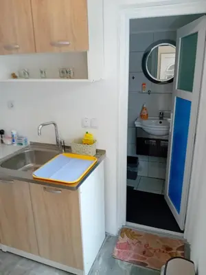 a small kitchen with a sink and a mirror at Ravne Apartman in Visoko