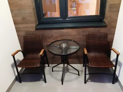 a glass table with two chairs and a table at Apartman Ladybug in Banja Luka