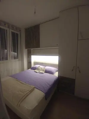 a bedroom with a bed with purple sheets and a window at Apartman Ladybug in Banja Luka