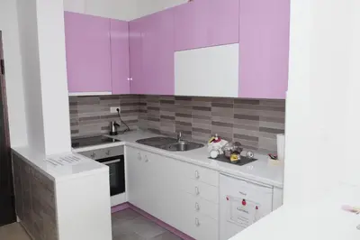 a kitchen with purple and white cabinets and a sink at Apartman Ladybug in Banja Luka