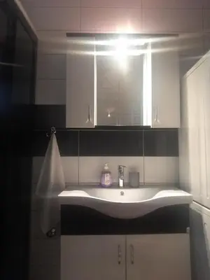 a bathroom with a sink with a light above it at VISOKO COMFORT suite in Visoko