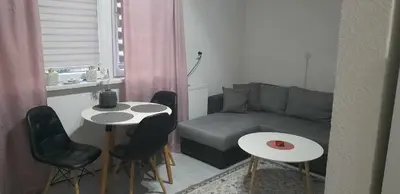 a living room with a couch and a table and chairs at VISOKO COMFORT suite in Visoko
