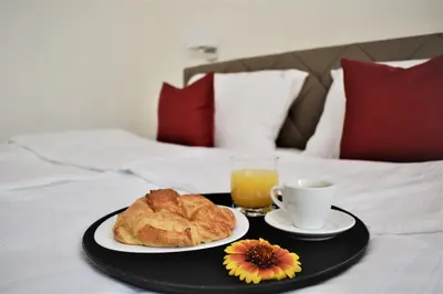 a tray with a plate of food and a cup of orange juice at Hotel Slavija Banja Luka in Banja Luka