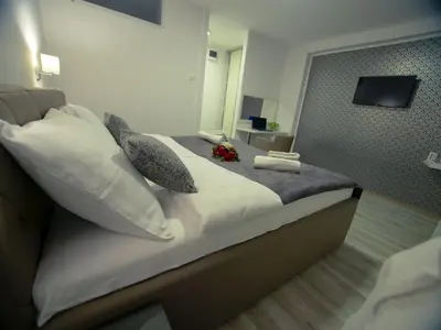 a bedroom with a bed with pillows and a mirror at Hotel Slavija Banja Luka in Banja Luka