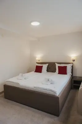 a bedroom with a large bed with red pillows at Hotel Slavija Banja Luka in Banja Luka