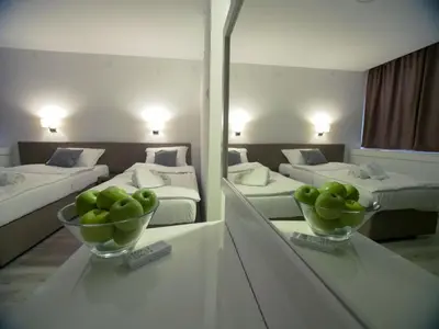 a room with two beds and two bowls of green apples at Hotel Slavija Banja Luka in Banja Luka