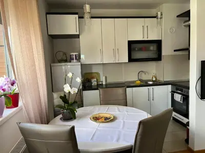 a small kitchen with a white table and chairs at Relax Teslić in Teslić