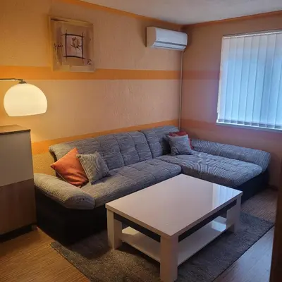 a living room with a blue couch and a table at Sana apartment in Sanski most